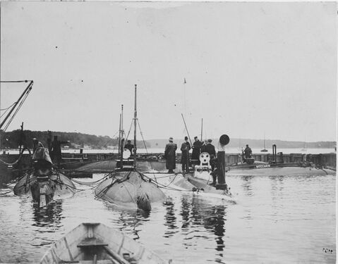Several of the Adder-class boats moored at the northern corner of the basin. Moccasin (Submarine No. 5) is in the right background.