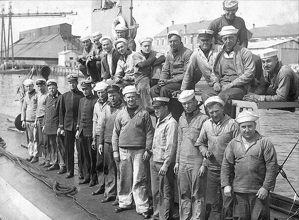 Ship's officers and crew posed on deck, 1917. She was then operating out of the U.S. Naval Submarine Base, New London, at Groton, Connecticut. The two officers (4th & 5th from left, front row) are Lieutenant (Junior Grade) Paul F. Foster (Commanding Officer) and Lieutenant (Junior Grade) William F. Callaway (Executive Officer).