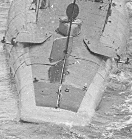 Closeup of the stern, showing details of the topside rudder, folded up stern planes, and the open aft torpedo room hatch.